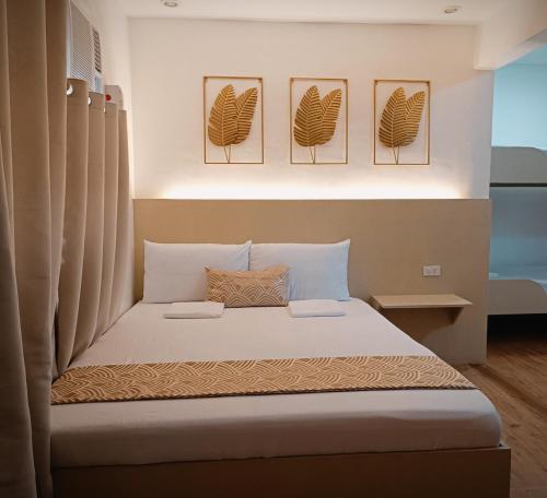 a bedroom with a bed with four pictures on the wall at Kaimito House - Guest House near Mactan-Cebu Airport in Lapu Lapu City