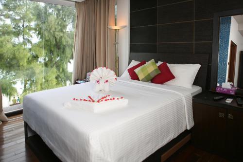a bedroom with a white bed with a cake on it at Ripple Beach Inn in Hulhumale