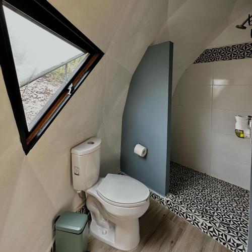 a bathroom with a toilet and a window at HOOGA glamping - Presa de Zimapán in Tecozautla