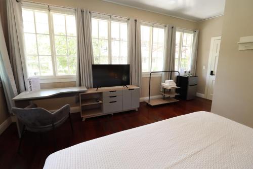 sypialnia z łóżkiem, biurkiem i telewizorem w obiekcie Casa Randa w Panamie