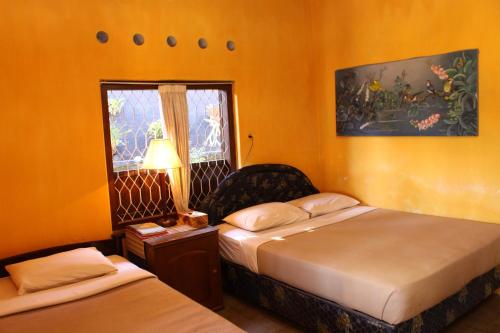 a hotel room with two beds and a window at Guru Ratna in Munduk