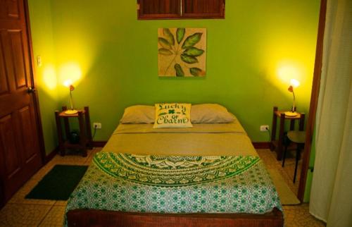 a bedroom with a bed in a green room at Villas Advi in Puerto Viejo