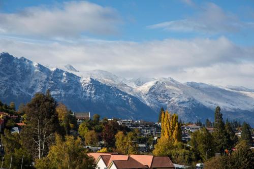 a city with snow covered mountains in the background at Pinewood Lodge in Queenstown