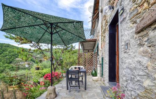 a table with a green umbrella on a patio at 1 Bedroom Nice Apartment In Moneglia in Moneglia
