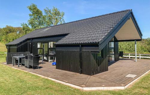 un grande edificio nero con un ponte di legno di Holiday Home Trappendalvej Hejls a Hejls