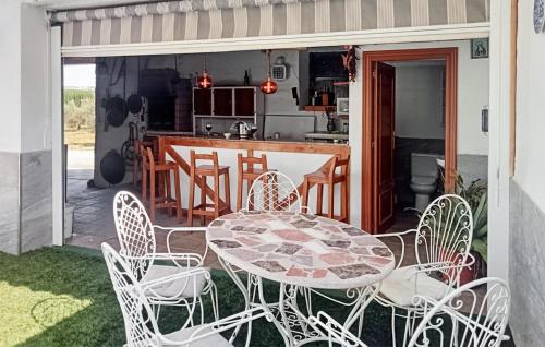 a patio with a table and chairs and a kitchen at Nice Home In Trasmulas, Granada in Trasmulas
