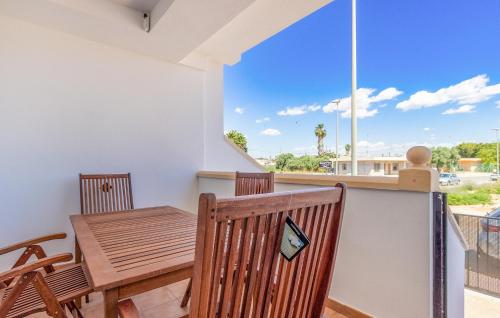 a dining room with a table and chairs and a balcony at Cozy Home In San Pedro Del Pinatar in San Pedro del Pinatar