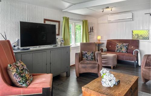 a living room with a flat screen tv and chairs at Stunning Stacaravan In Reeuwijk in Reeuwijk