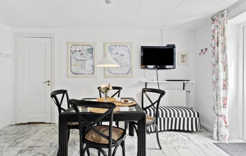 a dining room with a table and chairs and a tv at Lejl, 4 in Brovst