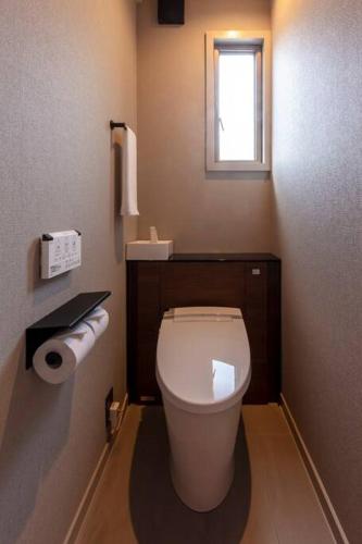 a small bathroom with a toilet and a window at Villa Secca in Futo