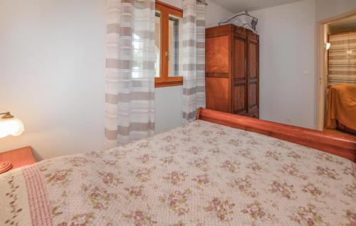 a bedroom with a bed and a dresser and a window at Lovely Apartment In Calcatoggio in Calcatoggio