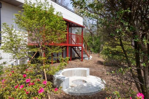 a house with a red deck and a bench in the yard at Villa Secca in Futo