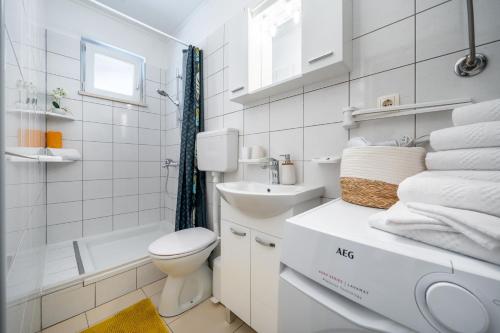 a white bathroom with a toilet and a sink at Holiday house with a parking space Dugi Rat, Omis - 23046 in Dugi Rat