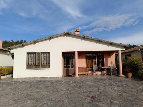 a white house with a porch and a patio at Casa Hotel Descanso Real in Paipa