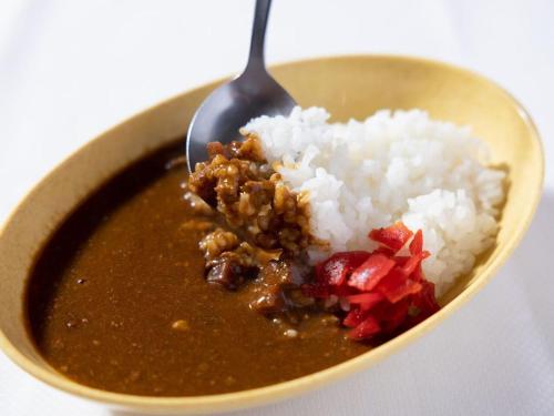 a bowl of soup with rice and a spoon at Hotel Taiyo Nouen Furumitsu in Matsuyama