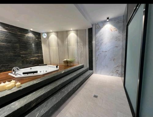 a bathroom with a tub and a glass wall at Santa Cruz de La Sierra - 3 Pago con Qr bedroom luxury apartment in Santa Cruz de la Sierra