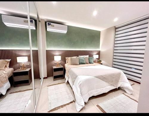 a bedroom with a bed and two tables with lamps at Santa Cruz de La Sierra - 3 Pago con Qr bedroom luxury apartment in Santa Cruz de la Sierra