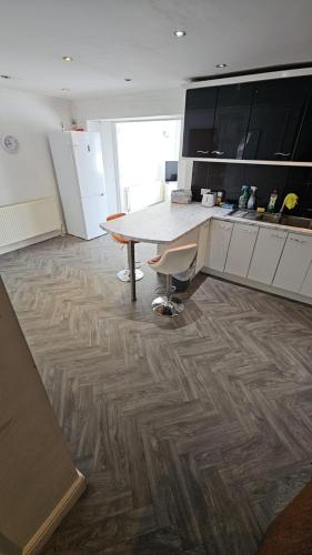 uma cozinha com piso em madeira e uma mesa em Sariyu space em Dagenham