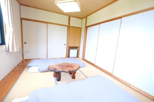 a room with two beds and a table in it at Arise Hakuba Lodge in Nagano