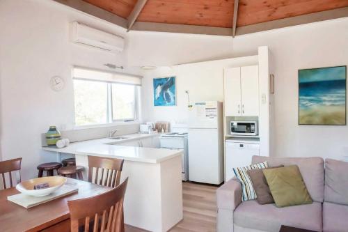 a kitchen and living room with a couch and a table at Aireys Inlet Getaway in Aireys Inlet