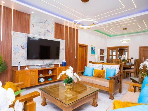 a living room with a couch and a tv at Villa doña kika in San Felipe de Puerto Plata