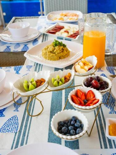 a table with plates of food and bowls of fruit at Villa doña kika in San Felipe de Puerto Plata