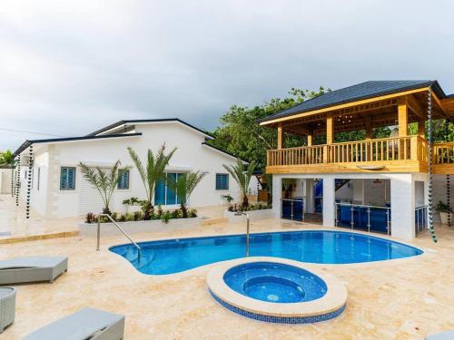 a house with a swimming pool in front of a house at Villa doña kika in San Felipe de Puerto Plata