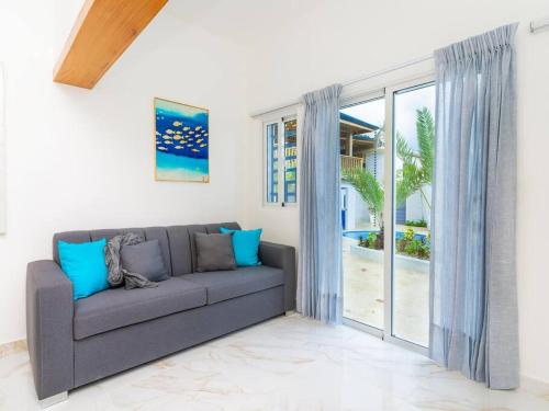 a living room with a couch and a sliding glass door at Villa doña kika in San Felipe de Puerto Plata