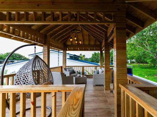 a wooden pergola with a table and chairs on a deck at Villa doña kika in San Felipe de Puerto Plata