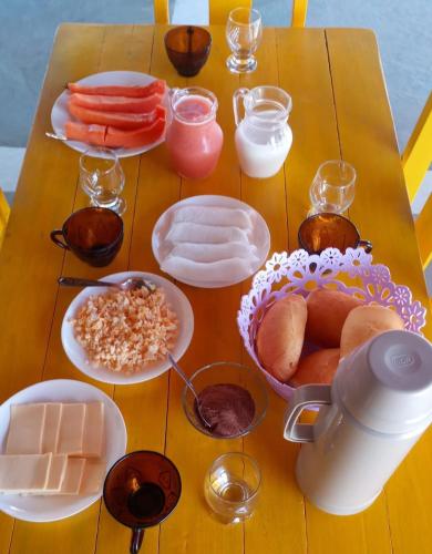a wooden table with plates of food on it at Aloha pousada & restaurante in Itapipoca