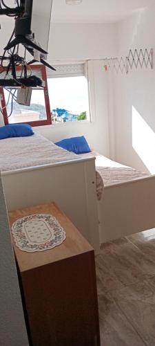Habitación pequeña con 2 camas y mesa. en EDIFICIO NOVOMAR 5to Piso en Mar de Ajó