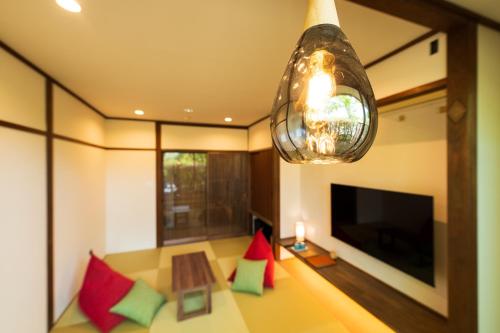 a living room with a table and a chandelier at Tokiwaso in Miyakonozyō