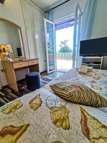 a bedroom with a bed and a desk and a mirror at Apartman Damir in Sumartin