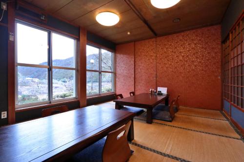an empty room with a table and some windows at 料理旅館ゆり野 in Wajiki