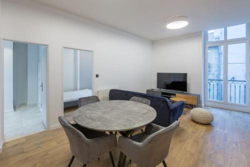 a living room with a table and chairs and a couch at T3 Hypercentre - Neuf, Equipé avec Parking à Proximité in Grenoble