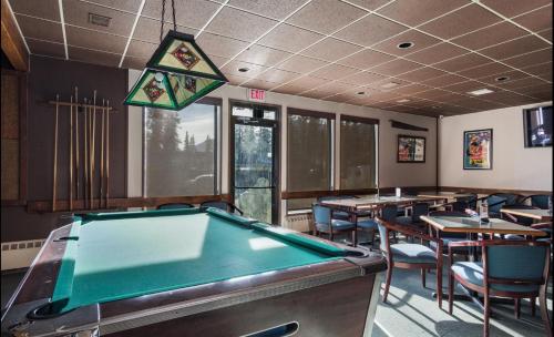 a pool table in a restaurant with tables and chairs at Talbot Arm Motel in Destruction Bay