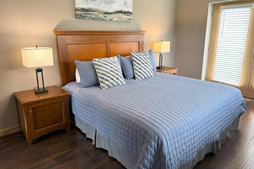 1 dormitorio con 1 cama con edredón azul y 2 lámparas en Mountain View Condos #3407, en Pigeon Forge