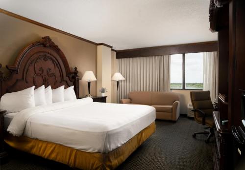 Habitación de hotel con cama grande y sofá en MCM Eleganté Hotel & Conference Center, en Beaumont