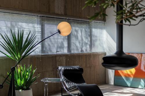 una lámpara en una habitación con una silla y una planta en Good Stand en Suao