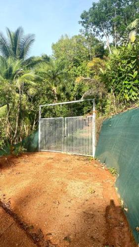 a white gate on a dirt road with trees at Azul Vista Drake Bay-AC-Full Kitchen in Drake