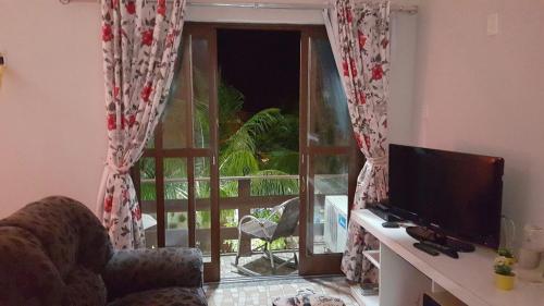 a living room with a television and a window at Pousada Recanto do Sal in Salinópolis