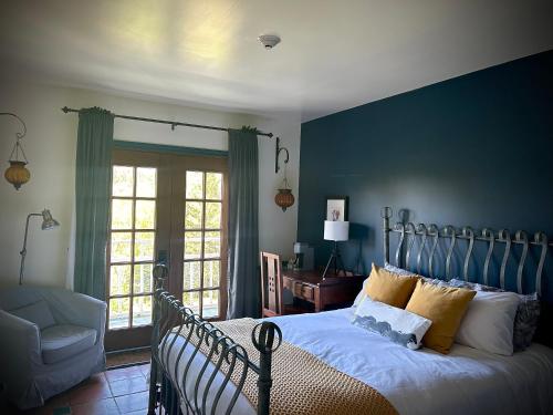 Schlafzimmer mit einem Bett mit blauer Wand in der Unterkunft Le Mange Grenouille in Bic