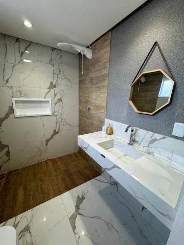 un bagno con lavandino e specchio di Casa de alto padrão a Natal