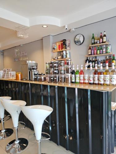 een bar met witte krukken in een restaurant bij JS786 Hostel in Pattaya