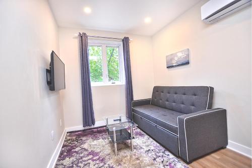 a living room with a couch and a window at Beautiful 2BDR in Heart of Plateau Mont-Royal A in Montréal