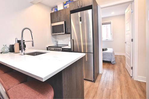 a kitchen with a sink and a refrigerator at Beautiful 2BDR in Heart of Plateau Mont-Royal A in Montréal