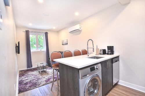 a kitchen with a sink and a washing machine at Beautiful 2BDR in Heart of Plateau Mont-Royal A in Montréal