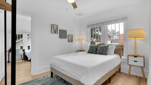 a white bedroom with a bed and a window at Beaches, Parks, Downtown, Trail, Breweries, Bikes, Gameroom in Palm Harbor