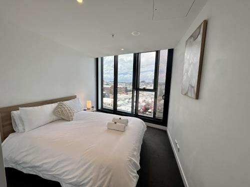 - une chambre avec un lit blanc et une boîte dans l'établissement Luxury 1-Bed with Infinity Pool, Gym & Parking, à Brisbane