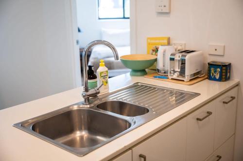a kitchen counter with a sink in a kitchen at Tranquil 2-Bed Inner City Retreat with Parking in Brisbane